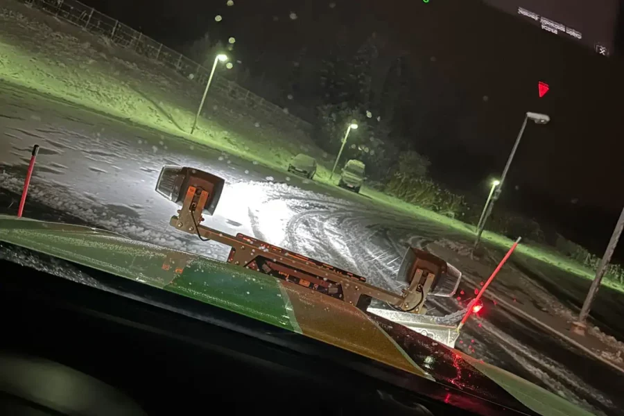 Blick aus einem Räumfahrzeug mit Schneepflug bei Nacht während des Winterdienstes in Rohrdorf bei Rosenheim.
